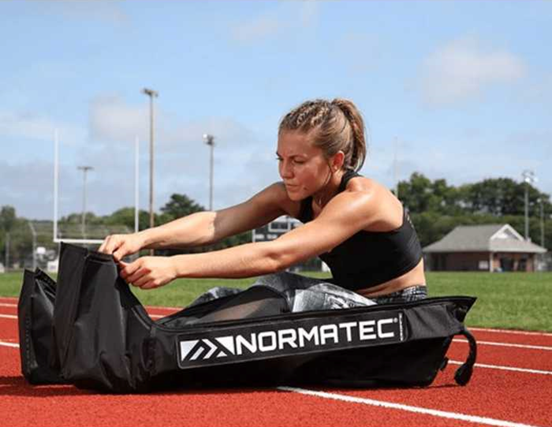 Image of female track athlete using compression boots
