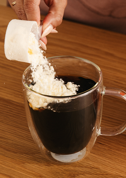 Photo of person adding delicious creamer to their coffee.