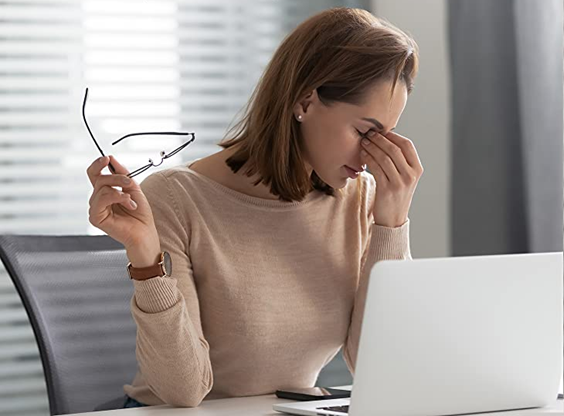 Photo of woman at her computer suffering from eye fatige