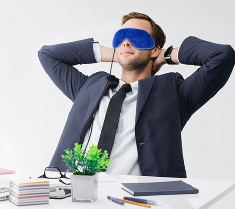 Photo of man relaxing at his desk with a heated eye mask