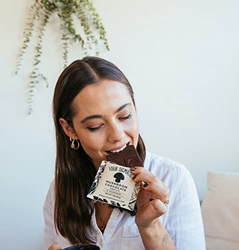 Photo of woman snacking on a Four Sigmatic bar.